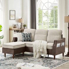 a living room scene with focus on the sectional sofa and footstool in the middle