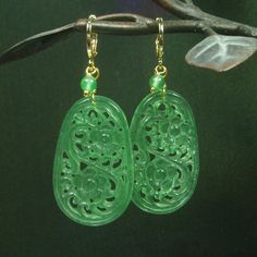 "What fantastic art piece of Jewelry.  Gorgeous artistic pierced vintage green jades in oval shaped.  They're elegantly covered in detail flowers on the both sides.  I added green jades are dangling on side.  They are connect to 16k gold filled leverback hooks.  They are earrings fall of stunning and mysterious and waiting for you to pick them up. Jade - a gemstone of unique symbolic energy, and unique in the myths that surround it.  With its beauty and wide-ranging expressiveness, jade has held Elegant Carved Round Earrings, Elegant Round Carved Earrings, Elegant Carved Drop Earrings, Elegant Carved Yellow Gold Earrings, Elegant Handmade Green Flower Earrings, Traditional Gold Carved Earrings, Green Drop Flower Earrings, Green Flower Drop Earrings, Traditional Pierced Flower Jewelry