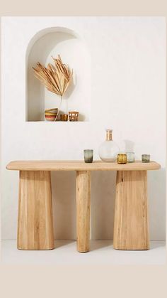 two wooden stools sitting next to each other in front of a white wall