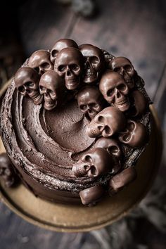 a cake with chocolate frosting and lots of skulls on it's top is sitting on a plate