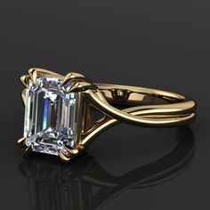 an emerald - cut diamond ring is shown in yellow gold with a twisted band around it