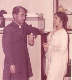 an old black and white photo of two people standing in a kitchen with one holding the other's hand