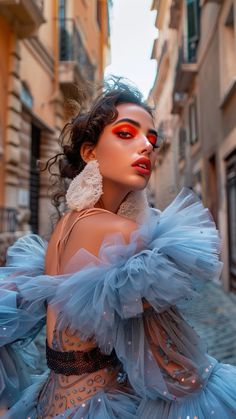 a woman in a blue dress is standing on the street