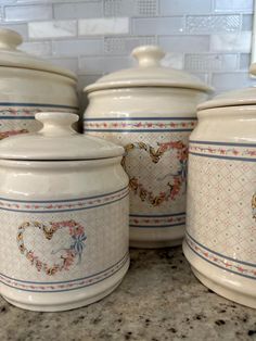 three white canisters sitting on top of a counter