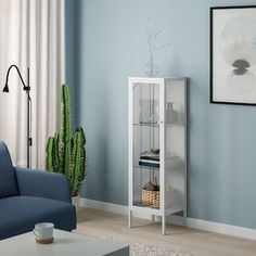 a living room with blue walls and a white cabinet in the corner next to a couch