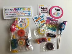 various candies and stickers are displayed on a white surface with the words you are amazing