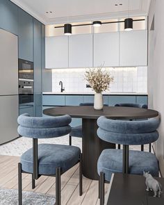 a kitchen with blue chairs and a round table