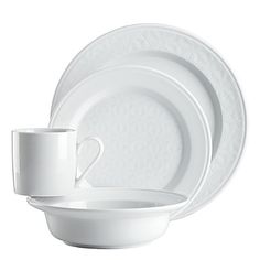 a white dinner set with two cups and saucers on the side, in front of a white background