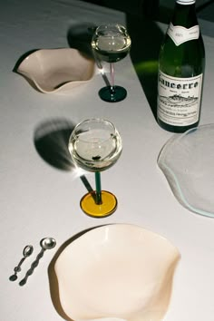 a table topped with wine glasses next to a bottle of wine and a pair of scissors