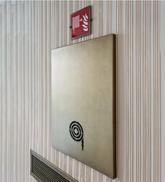 a metal sign mounted to the side of a wall next to a heater and radiator