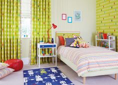 a child's bedroom with yellow curtains and colorful bedding