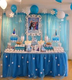 a table topped with lots of desserts and balloons in front of a blue curtain