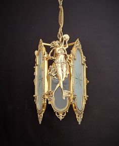 a gold necklace with an image of a woman holding a bird on it's back