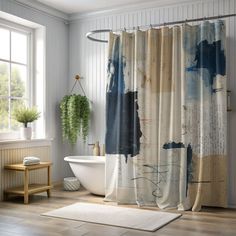 a bathroom with a bathtub, rug and shower curtain that has an abstract painting on it