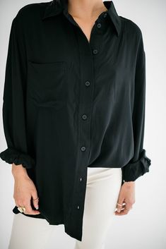 A timeless wardrobe essential that seamlessly combines style and comfort. Our Marino button up is designed with a modern, relaxed fit that drapes perfectly, providing a flattering silhouette for all body types. Size Chart Features: oversized fit collared neckline buttons front pocket buttoned cuffs fabric content: 100% rayon model is wearing a small. Height 5'7" Bust 34", Waist 25", Hip 36" Versatile Fall Blouse With Roll-up Sleeves, Oversized Blouse With Roll-up Sleeves And Shirttail Hem, Sleek Relaxed Fit Blouse For Work, Oversized Blouse With Roll-up Sleeves And Spread Collar, Effortless Layering Blouse For Fall, Sleek Spread Collar Blouse For Fall, Effortless Fall Layering Blouse, Sleek Blouse With Spread Collar For Fall, Chic Shirt With Hidden Button Closure For Fall