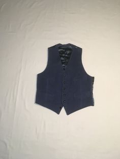 "vintage 1970s men's waistcoat vest smokey blue corduroy front braided black buttons 4 pocket front blue acetate feel backing corduroy feels cotton, might have a blend of small amount of synthetic double v front hem straight hem back back waist sash good vintage condition, light wear, bottom button is decorative, doesn't lay properly buttoned labeled 42 Reg, see below measures, lying flat, shoulder-12\" chest-21\" waist-18 1/2\" hem-19\" length-27\"    All sales final, no returns/exchanges. Please feel free to contact us with any questions you may have about an item prior to purchase and we will gladly answer them." Fitted Cotton Vest With Button Closure, Classic Fitted Navy Vest, Navy Fitted Classic Vest, Classic Navy Fitted Vest, Navy Fitted Winter Vest, Navy Fitted Vest For Winter, Vintage Tailored Single Breasted Vest, Fitted Retro Vest With Button Closure, Retro Fitted Vest With Button Closure