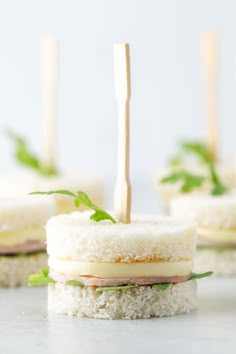 small sandwiches with toothpicks sticking out of them on a counter top, ready to be eaten