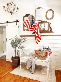 an american flag is hanging on the wall next to a bench and potted plant