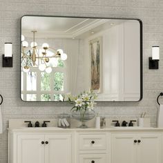 a bathroom with two sinks and a large mirror on the wall over it's vanity