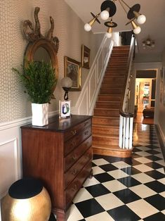 a black and white checkered floor in a house with stairs leading up to the second floor