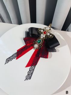 Elevate your outfit with our stunning Baroque-inspired Beads and Rhinestones Brooch or Bow Tie. Available in a striking black or red color, this exquisite accessory features intricate detailing and a cross design, adding a touch of vintage glamour to your look. Whether you choose to adorn your lapel or collar with this statement piece, it's the perfect way to showcase your unique style.   Please note that this product includes only one brooch or bow tie. Elegant Rhinestone Brooch For Party, Elegant Embellished Evening Brooch, Gothic Brooch Jewelry For Parties, Gothic Party Brooch Jewelry, Elegant Black Jewelry For Costume Party, Black Brooch Jewelry For Party, Black Party Jewelry Brooch, Red Embellished Party Jewelry, Red Beaded Brooch For Party