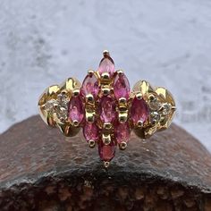 Gorgeous Rubies accented by Diamonds set in a Lovely 14k Yellow Gold Cluster Ring. US Size 7 3/4 Rubies approximately 1.1 ctw Diamonds 0.08 ctw, approximately  Diamond Grade: J / I Widest Point measures approximately 13.6 mm. Back of the shank tapers down to 2.1 mm, approximately. Nicely weighted at 3.6 grams, approximately. Stamped 14K Ruby is the birthstone for July. Diamond is the birthstone for April. Cubic Zirconia Marquise-cut Multi-stone Diamond Ring, Marquise Cut Multi-stone Cubic Zirconia Diamond Ring, Multi-stone Cubic Zirconia Marquise Cut Ring, Diamond Cluster Ruby Ring With Diamond Accents, Formal Ruby Ring With Diamond Accents In Cluster Shape, Marquise Cut Multi-stone Diamond Ring For Anniversary, Cluster Diamond Ring With Vvs Clarity And Ruby, Formal Cluster Ruby Ring With Diamond Accents, Classic Diamond Ring With Multi-stone Marquise Cut