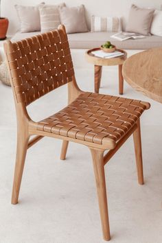 a wooden chair sitting next to a table on top of a white carpeted floor