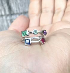 - Mothers ring - Family birthstone ring - Unique gift for her - Mom's birthday - Mom's wedding gift - Sister's birthday - Christmas Gift - Modern geometrical ring - Statement ring Besides it's modern look this unique multi-color gemstone ring can have a great sentimental value by representing your family! MaterialGold (14K & 18K) or PLATINUM 950 FinishingHigh Polished/ Shiny FitComfort/ Rounded Width & height2mm Setting typeBezel StonesNatural Gemstones Baguette Emerald (3x5mm) Round Ale May Birthstone Gemstones With Accent Stones For Gifts, May Birthstone Gemstones With Accent Stones, Unique Multi-stone Birthstone Promise Ring, Round Multi-stone Gemstones For May Birthstone, Multi-stone Jewelry For May Birthstone Anniversary, May Birthstone Multi-stone Jewelry For Anniversary, Fusion Style Birthstone Jewelry For Anniversary, Fine Jewelry Stackable Gemstones As Gifts, Fine Jewelry Stackable Gemstones For Gift