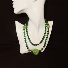 On offer is this spectacular Vintage Chinese 36 Inches Long Green Nephrite Jade Beaded Necklace with 14 Karat Yellow Gold Corrugated Spacer Beads and a huge roung central Hand Carved and Pierced Translucent Green Jade Pendant with Two Shou Design Carved Green Jade Beads.  The necklace is hand knotted with green silk cord with no clasp because it easily slips over your head.  The green Nephrite Jade is highly polished so it gleams with a deep luster.  The Nephrite Jade beads measure 8mm in diamet Antique Carved Jade Pendant And Beaded Necklace, Green Jade Long Necklace, Elegant Green Long Necklace As Gift, Jade Gemstone Beads Long Necklace, Elegant Green Hand-strung Necklace, Formal Green Hand-strung Jewelry, Formal Green Single Strand Beaded Necklace, Green Jade Necklace With 108 Beads, Elegant Hand-strung Jade Necklace