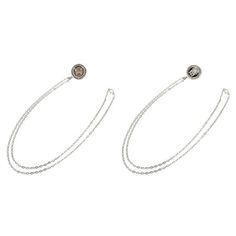 two silver earrings with chains on the bottom and one has a round stone in the middle