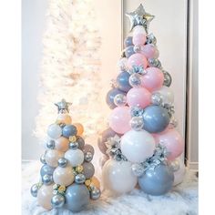 a christmas tree made out of balloons and other decorations in front of a white christmas tree