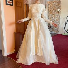 a mannequin wearing a wedding dress and veil in a room with red carpet