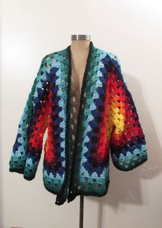 a crocheted jacket is displayed on a mannequin