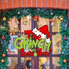 the grin lives here sign is displayed in front of a store window decorated for christmas