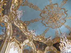 an ornately decorated room with chandeliers and paintings on the ceiling in gold, blue and white