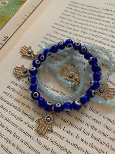 two stretchy bracelets for protection against Jealousy.  Light blue Hamsa wraps around wrist or ankle 2 to 3 times. Dark blue hamsa evil eye stretchy bracelet glass beads Cheap Blue Evil Eye Bracelets, Adjustable Evil Eye Bracelets For Meditation, Blue Beaded Spiritual Stretch Bracelet, Blue Adjustable Stretch Bracelet For Healing, Adjustable Blue Stretch Bracelet For Healing, Blue Spiritual Stackable Jewelry, Blue Bohemian Stretch Bracelet For Meditation, Bohemian Blue Stretch Bracelet For Meditation, Adjustable Blue Crystal Bracelet For Meditation