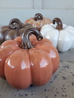 pumpkins and gourds are sitting on the concrete