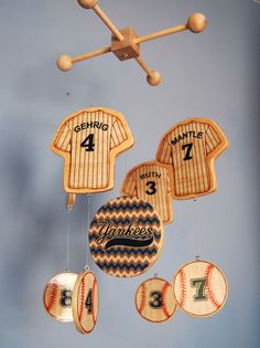 a baseball themed mobile hanging from the ceiling in a child's room with numbers on it