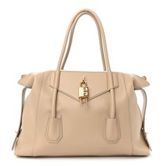 This is an authentic GIVENCHY Smooth Calfskin Medium Antigona Lock Duffle Bag in Beige. This stylish tote is crafted of luxuriously smooth calfskin leather in beige. The bag features sturdy rolled leather top handles with gold hardware and extended sides. The top opens to a matching fabric interior with a patch pocket. Luxury Beige Shoulder Bag For Everyday, Cream Calf Leather Bags With Palladium Hardware, Everyday Luxury Beige Calf Leather Shoulder Bag, Elegant Taupe Shoulder Bag With Metal Hardware, Elegant Taupe Shoulder Bag With Palladium Hardware, Cream Shoulder Bag With Palladium Hardware For Office, High-end Beige Calf Leather Bag, Luxury Cream Calf Leather Shoulder Bag, Elegant Cream Calf Leather Shoulder Bag