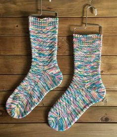 a pair of socks hanging on a clothes hanger next to a wooden wall with wood planks