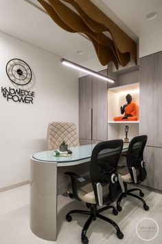 an office with two chairs and a desk in front of a clock on the wall