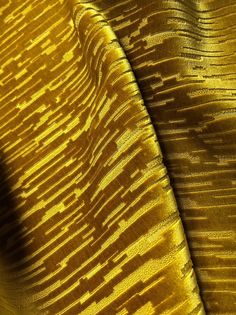 close up view of the texture of a yellow velvet fabric with an interesting pattern on it