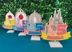 there are five little princess tiaras on top of each other in front of some bushes