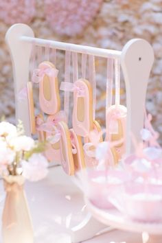 a table topped with pink cookies and cupcakes