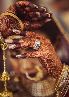 a close up of a woman's hands with hennap and jewelry on