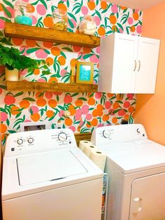 a washer and dryer in a small room with wallpaper on the walls