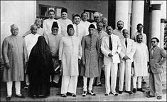 a group of men standing next to each other in front of a white building with columns