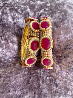 Absolutely stunning piece of meena bangle .Available in ruby and emerald green size 2/2 and 2/4, 2 of each size. You will receive one bangle. If you would like to buy two bangles contact me for combine shipping please if you have any queries please ask Pink Kundan Bangle For Gift, Pink Kundan Bangle For Festive Occasions, Round Meenakari Bangle As Gift, Pink Hand Set Bangle As A Gift, Handmade Ruby Bangle Bracelet, Festive Pink Bangle With Stone Work, Red Ruby Bangle As Gift, Stone Work Bangle As A Gift, Red Handmade Bollywood Bracelets