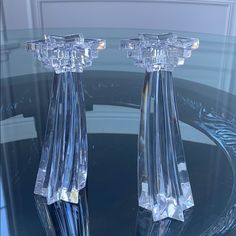 two crystal candlesticks sitting on top of a glass table