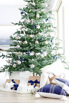 a white christmas tree with blue and silver ornaments